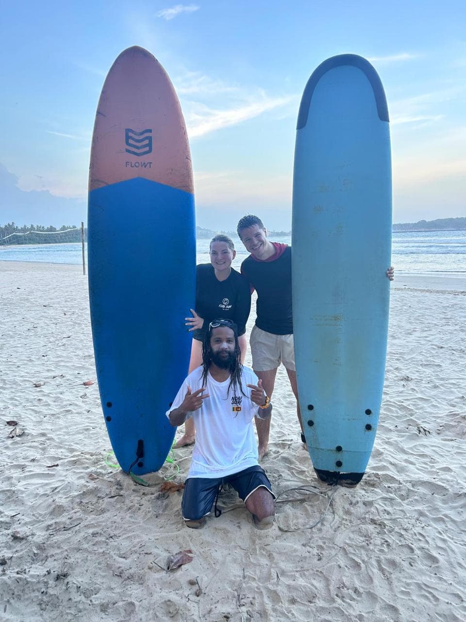 Soft-top surfboards lined up at sunset